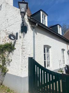a white brick building with a street light on it at Het Molenaarshuis in Vijverbroek