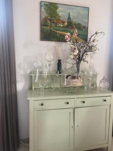 a table with glasses and a vase of flowers on it at Het Molenaarshuis in Vijverbroek