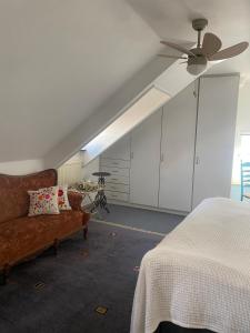 a living room with a couch and a ceiling fan at Het Molenaarshuis in Vijverbroek +5 photos