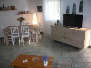 a living room with a television and a dining room table at Villa Davima in Marzamemi