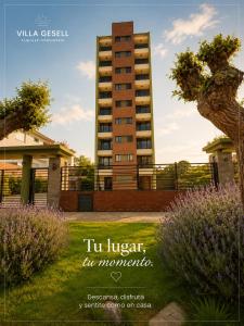 a tall apartment building in the middle of a yard at Reflejo de Mar in Villa Gesell
