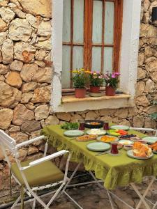 a table with plates of food and a window at Old Kalamaki Pansiyon in Kalkan