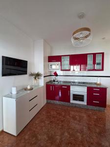 a kitchen with red and white cabinets and appliances at Roque`s House A in Telde