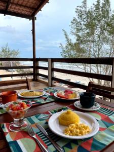 a table with plates of food on a table with the beach at Pousada Mahalo Preá Beach in Prea +90 photos