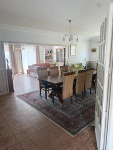 a dining room and living room with a table and chairs at Trégouet 8 - Chambre 3 in Saint-Nazaire