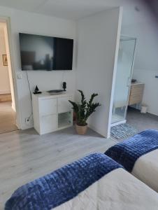 a bedroom with a flat screen tv on a wall at Trégouet 8 - Chambre 3 in Saint-Nazaire