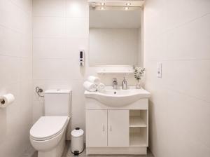 a white bathroom with a toilet and a sink at Pension Elisa in Rheinfelden