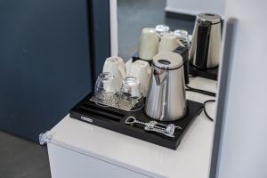 a counter with a tray with silver appliances on it at Crystal Beach Rooms by PS in Durrës