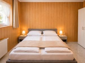 a bedroom with a large bed with two lamps on two tables at Pension Elisa in Rheinfelden