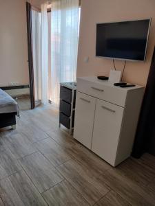 a room with a tv and a white dresser with a television on top at Gagin San -apartman na plaži in Veliko Gradište