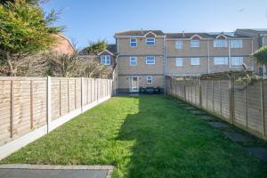 a yard with a fence and a building at Seaview in Clacton-on-Sea