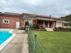 a house with a fence and a swimming pool at villa Soleil 3chambres piscine in Lagorce