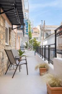 a patio with a chair and plants on a balcony at Aesop Homes in Pythagoreio