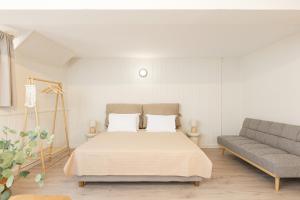 a bedroom with a bed and a couch at Aesop Homes in Pythagoreio