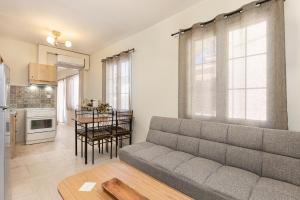 a living room with a couch and a kitchen at Aesop Homes in Pythagoreio