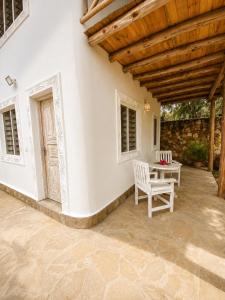 a patio with a table and chairs and a wooden ceiling at Blue Diamond Villa Watamu in Watamu