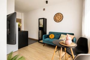 a living room with a blue couch and a table at PiotrApartments - Central Warsaw Wilcza - Luxury Apartment - Prime Location in Warsaw +26 photos
