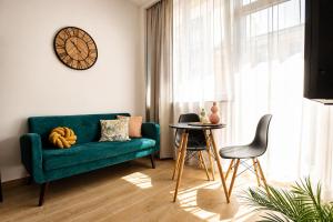 a living room with a green couch and a table at PiotrApartments - Central Warsaw Wilcza - Luxury Apartment - Prime Location in Warsaw