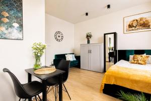 a bedroom with a bed and a table and chairs at PiotrApartments - Central Warsaw Wilcza - Luxury Apartment - Prime Location in Warsaw