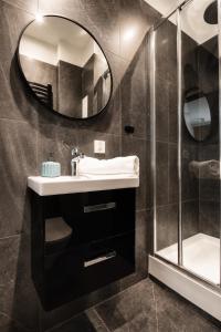 a bathroom with a sink and a mirror at PiotrApartments - Central Warsaw Wilcza - Luxury Apartment - Prime Location in Warsaw