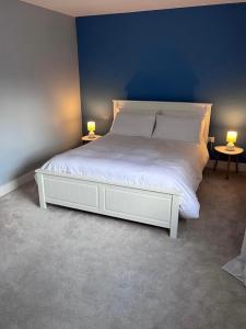 a bedroom with a white bed with two lamps at Knockeven Hidden Gem in Waterford