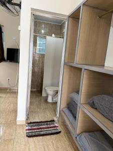 a bathroom with a toilet and a shower with a mirror at Recanto dos Amigos Suítes CANTÃO DO INDAIA in Bertioga