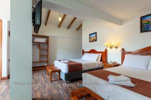 a hotel room with two beds and a tv at Hotel Amerinka in Cusco