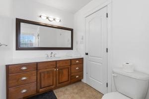 a bathroom with a toilet and a sink and a mirror at Spacious 4BR Family Retreat w- Game Room 10p in Dieppe +23 photos