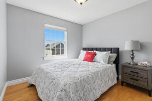 a white bedroom with a bed and a window at Spacious 4BR Family Retreat w- Game Room 10p in Dieppe