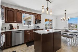 a kitchen with wooden cabinets and white counter tops at Spacious 4BR Family Retreat w- Game Room 10p in Dieppe