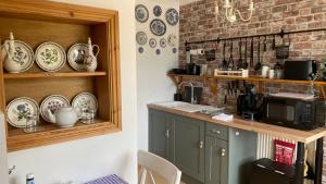 a kitchen with a counter with plates on the wall at 'Tanglemere' in Broadway