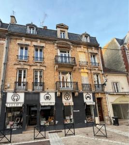 a large brick building with windows and balconies at Le Clos Langevin in Épernay