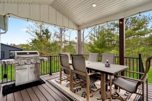 a patio with a table and a grill on a deck at Four Sisters Cottage- Walk to Sister Bay, Fireplace, Ping Pong & More in Sister Bay