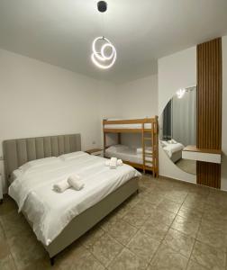 a bedroom with a large white bed and a bunk room at Fusha Apartment in Velipojë