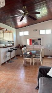 a living room with a ceiling fan and a table at Pépite Anses in Les Anses-dʼArlets +3 photos