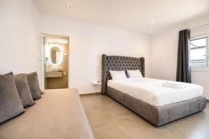 a bedroom with a large bed and a couch at ATH Airport Suites Free Shuttle From And To Athens Airport in Spata
