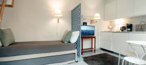 a small room with a bed and a kitchen at PARIS AUTHENTIC HOUSE Métro 7 Pierre et Marie Curie in Paris