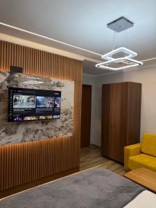 a living room with a television on a wall at Hotel Exclusive in Tirana