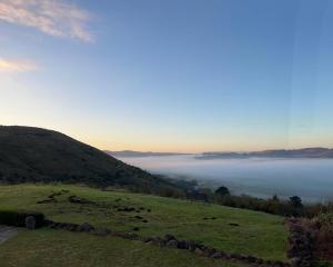 a view of a foggy valley with the sun rising over a hill at Highveldt Farm, Nottingham Road in Fort Nottingham