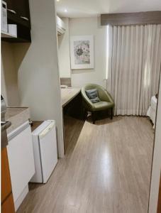 a kitchen with a desk and a chair in a room at Alugo Suite 303 No Mont Blanc in Nova Iguaçu