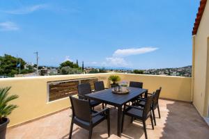 a patio with a table and chairs on a balcony at ATH Airport Suites Free Shuttle From And To Athens Airport in Spata