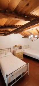 two beds in a room with wooden ceilings at Monte do Rei Santo in Arronches +88 photos