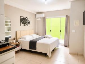 a bedroom with a bed and a large window at Isa Flats in Janaúba