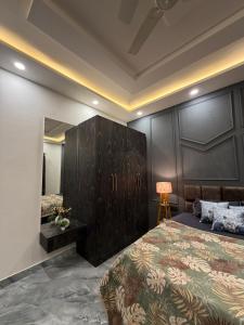 a bedroom with a large bed and a wooden cabinet at Aura Villa in Ghaziabad