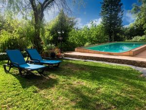 a pair of chairs sitting in the grass next to a swimming pool at Monte do Rei Santo in Arronches