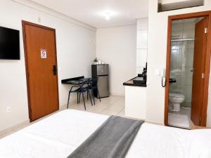 a hotel room with a bed and a bathroom at Isa Flats in Janaúba