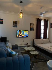 a living room with a couch and a tv at Imastay in Mombasa