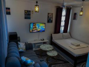 a small living room with a bed and a couch at Imastay in Mombasa +8 photos