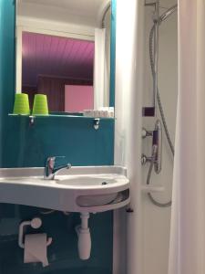a bathroom with a sink and a mirror at Tattoo PENSION mit Restaurant und Tattoo-Studio in Mörtschach