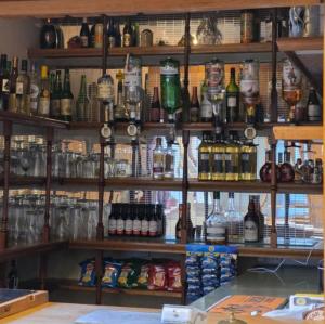 a shelf filled with lots of bottles of alcohol at Hylands Hotel Double Room with Private Bathroom & Free Parking in Nottingham +17 photos